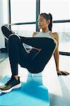 Young woman exercising in gym, stretching