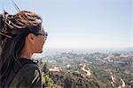 Young woman looking out at landscape from Hollywood sign, Los Angeles, California, USA