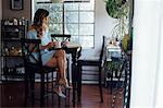 Sophisticated young woman reading book at table