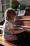 Girl at home playing old piano