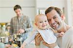Portrait smiling gay father holding cute baby son