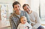 Portrait smiling male gay parents with baby son