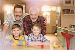 Portrait smiling male gay parents and children playing board game at table