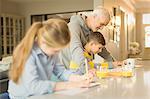 Father helping son with homework at counter