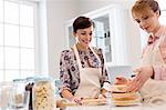 Female caterers baking layer cake in kitchen