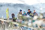 Skier friends talking and drinking cocktails on sunny balcony apres-ski