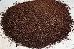 Close up of a heap of dark brown malt, a major flavouring ingredient in the beer brewing process.
