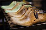 Close up of various wooden shoe forms in a shoemaker's workshop.