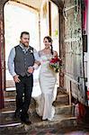 Smiling bride and groom entering church.