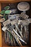 Overhead view of stamped traditional metal plant labels in a box.