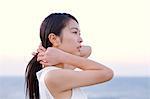 Young Japanese woman in a white dress at a cliff over the sea at sunrise, Chiba, Japan