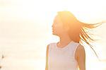 Young Japanese woman in a white dress at a cliff over the sea at sunrise, Chiba, Japan
