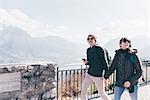 Couple strolling above lakeside, Monte San Primo, Italy