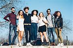 Portrait of group of friends, standing on ledge