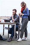 Male and female design team looking at digital tablet on waterfront outside design studio