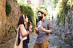 Couple with ice cream cones on cobbled street, Arezzo, Tuscany, Italy