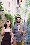 Portrait of couple with ice cream cones on cobbled street, Arezzo, Tuscany, Italy