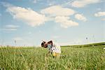 Female toddler bending forward in field picking grass