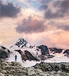 Hiker looking at clouds on snow covered mountains, Mount Baker, Washington, USA