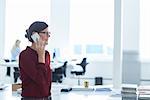 Woman in office making telephone call using mobile phone