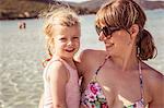 Portrait of mother and daughter at beach, smiling