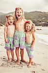 Portrait of three young sisters on beach, smiling