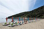 Empty beach with rows of beach umbrellas and sun loungers, Dubrovnik, Croatia