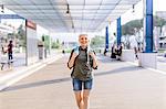Portrait of mature female backpacker walking in bus station, Scandicci, Tuscany, Italy