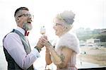 1950's vintage style couple with ice cream cone, laughing on pier