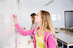 Teenage girl writing on whiteboard