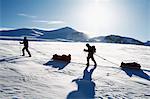 Tourists cross country skiing against mountain scenery