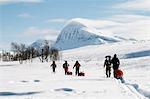 Tourists cross country skiing against mountain scenery