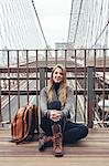 Young woman sitting on bridge