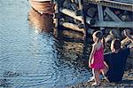 Boy and girl skimming stones in lake