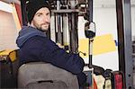 Portrait of mechanic sitting on forklift