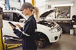 Female mechanic using digital tablet