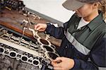 Female mechanic checking a car parts