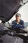 Portrait of female mechanic standing with arms crossed