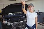 Female mechanic in garage holding car key