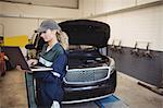 Female mechanic using laptop