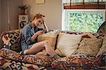 Tensed woman using mobile phone in living room