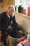 Woman holding dog in bathtub