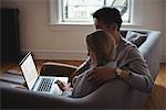 Couple using laptop in living room