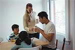 Woman serving coffee to man