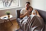 Romantic couple relaxing on sofa in living room