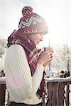 Beautiful woman in winter wear having a drink in cup