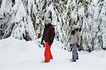 Skier couple walking on snowy mountain