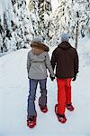 Skier couple walking on snow covered mountain