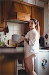 Woman standing and holding a bowl in kitchen