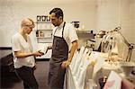 Male and female barista checking packaging of coffee in coffee shop